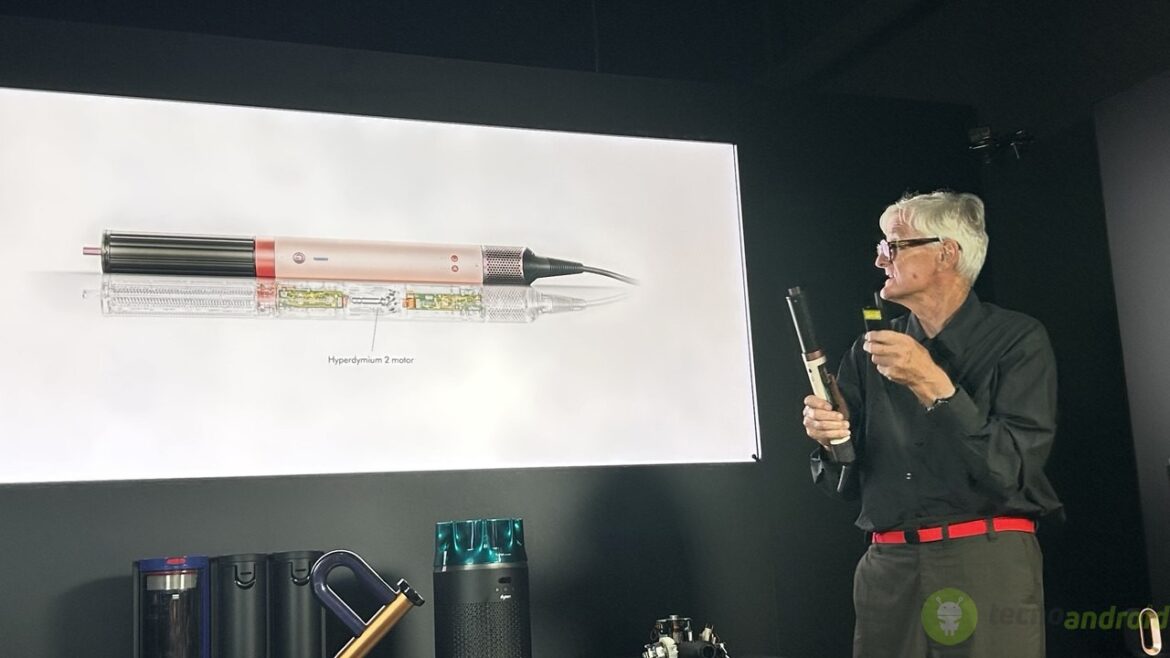 Dyson IFA 2025 (3) Penna digitale con motore Hyperdymium 2, presentata durante una conferenza tecnologica, con un esperto che analizza il dispositivo in primo piano.