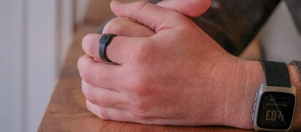 Tecnologia smartwatch fitness. Braccia di uomo con smartwatch e anello smart sul polso e dita.