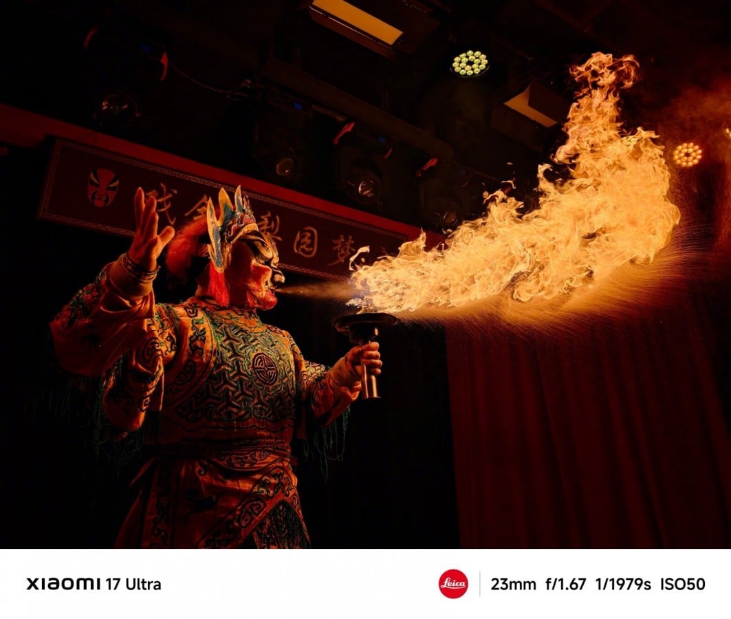 Fuoco e danza tradizionale cinese durante spettacolo culturale, performance artistica con maschera e costume colorato, fuoco che esce dalla bocca del performer, atmosfera notturna e teatrale.