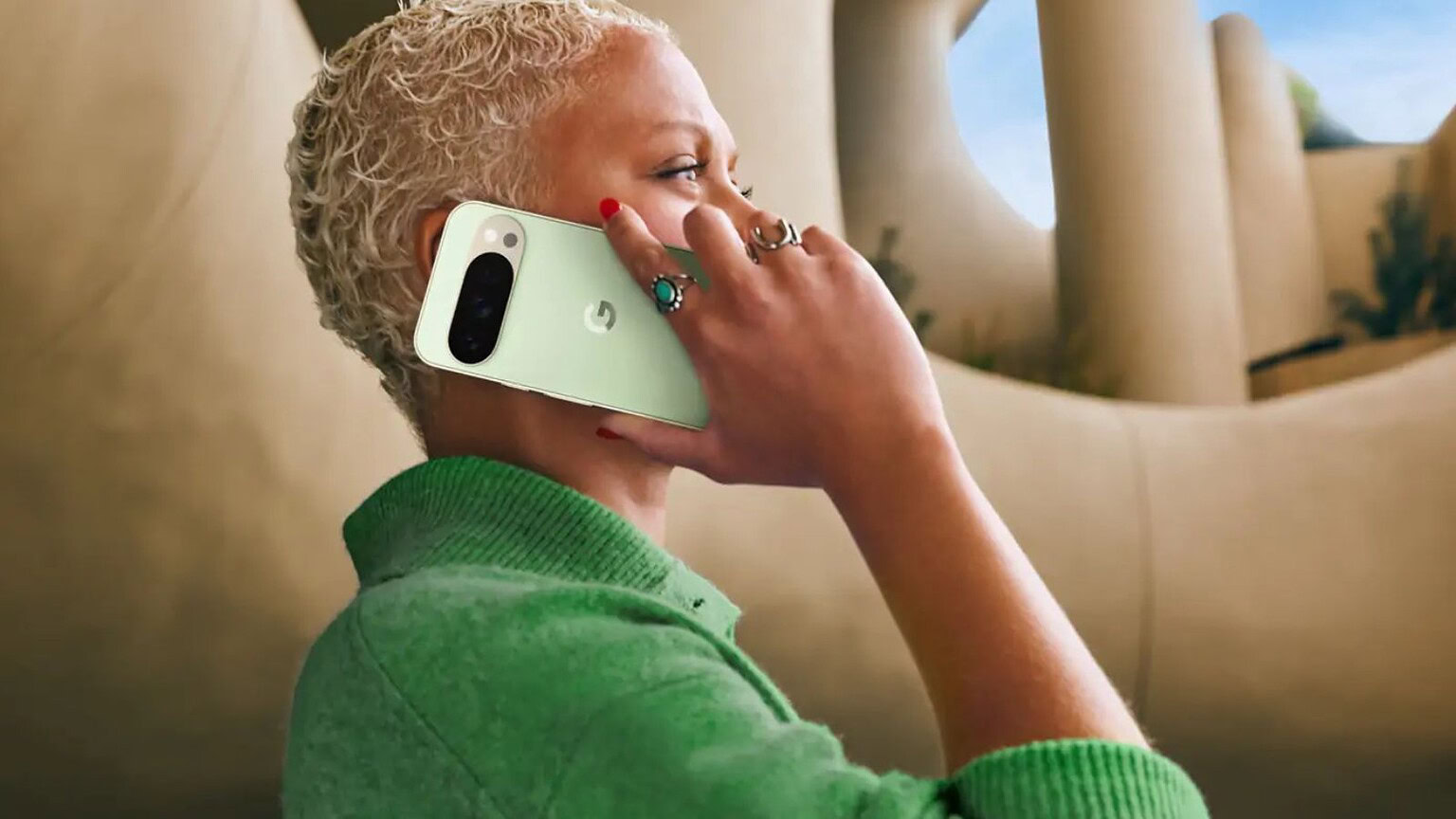 Telefono Google Pixel 4a, donna con pelle chiara, capelli ricci biondi e smalto rosso, utilizza lo smartphone in un ambiente elegante, evidenziando le caratteristiche avanzate del dispositivo e il focus su tecnologia e design moderno.