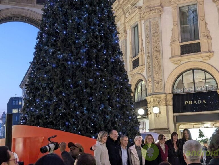 lenovo albero natale - utilizzo Albero di Natale decorato con luci blu a Milano, in un evento natalizio con un grande gruppo di persone, sotto un monumentale edificio storico con negozi di alta moda.