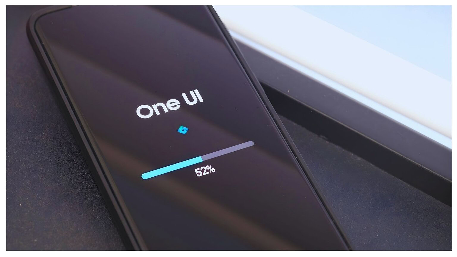 Telefono con caricamento One UI 52%.