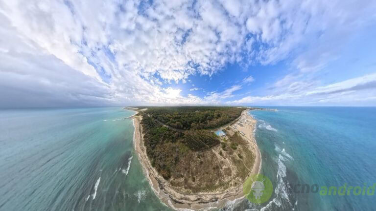 Tranquillo panorama costiero con mare cristallino e cielo nuvoloso. Spiaggia e mare in primo piano con cielo nuvoloso, vista panoramica di un'isola con vegetazione e spiagge, perfetta per contenuti sulla natura, vacanze e turismo.