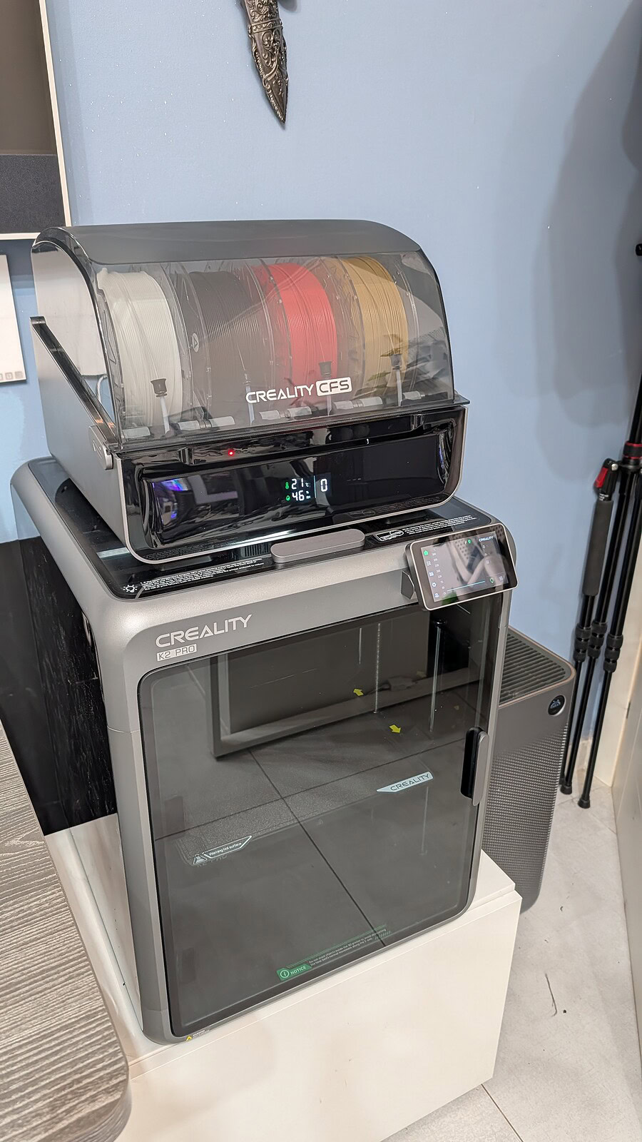 Creality K2 Pro Combo - utilizzo Immagine di una stampante 3D Creality, modello linewidth K2 PRO, al lavoro in un ambiente di lavoro o studio, con bobine di filamento colorate visibili.