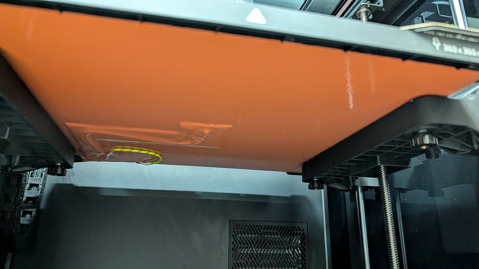 Creality K2 Pro Combo - immagine 23 Alt text: Dettaglio di una stampante 3D industriale che stampa un oggetto in plastica arancione con precisione elevata.