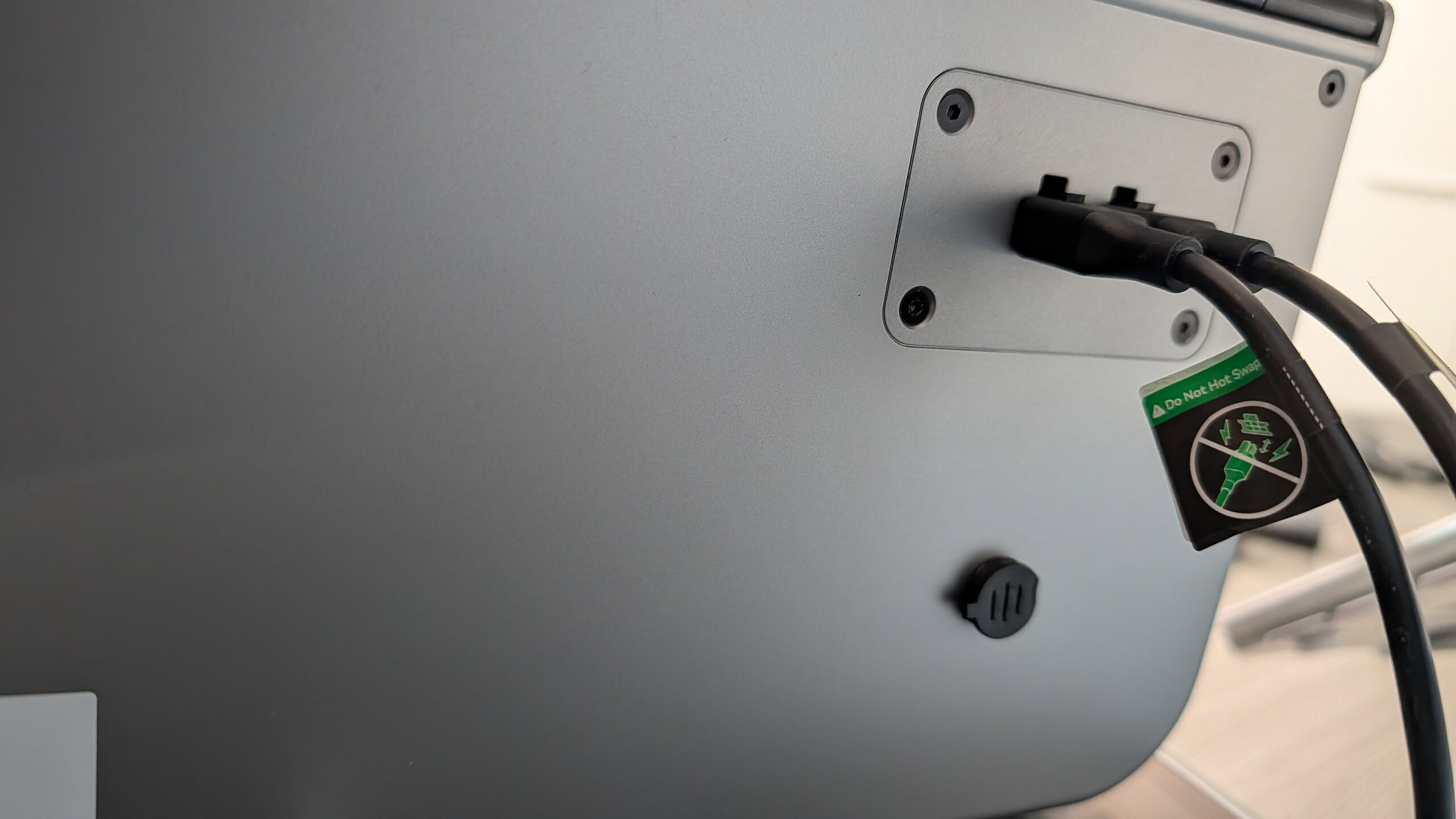 Monitor PC con cavi collegati e etichetta di sicurezza anti surriscaldamento. Immagine di un monitor da ufficio con cavi di alimentazione collegati e adesivo di sicurezza per evitare surriscaldamenti.