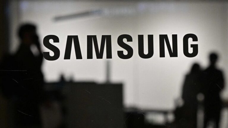 Immagine con logo Samsung sfocato, persone al lavoro, ambiente tecnologico, innovazione, dispositivi Samsung, alta qualità, prodotti di elettronica, smartphone, tecnologia all'avanguardia, digitale.