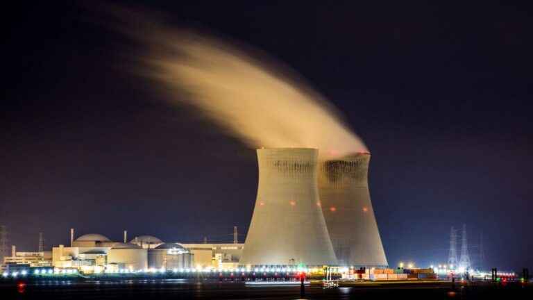 Immagine di una centrale nucleare con turbogeneratori e altissime torri di raffreddamento illuminata di notte, con vapori che si alzano nel cielo scuro. Perfetta per contenuti su energia nucleare, sicurezza atomica e tecnologia energetica.