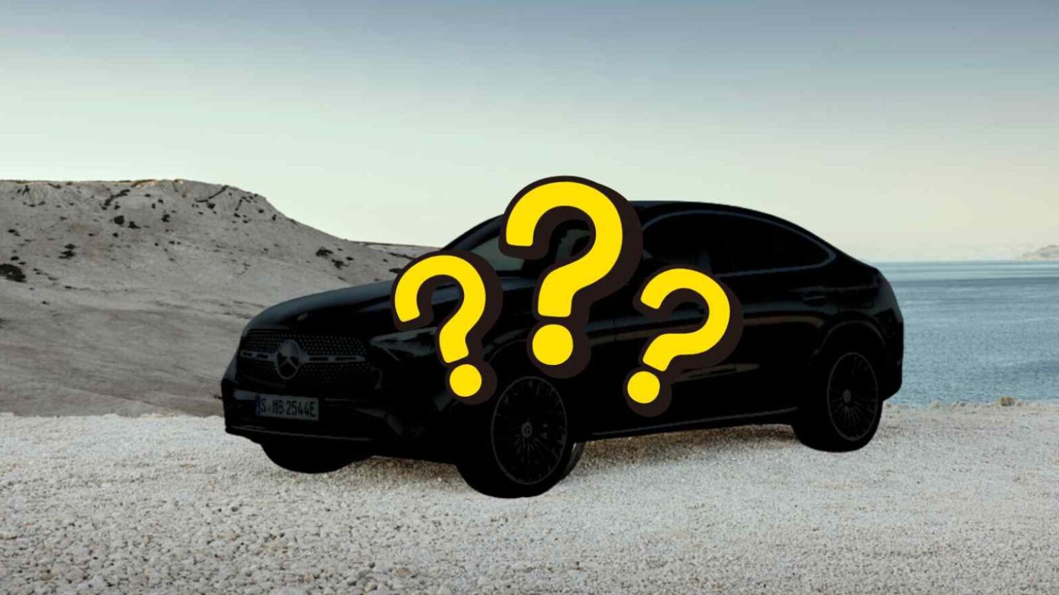 Auto Mercedes EQC nera con domande gialle sovrapposte, sfondo paesaggio desertico e mare, evento di lancio o teaser veicolo elettrico.
