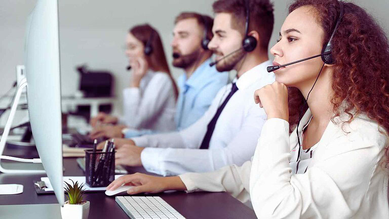 Operatore del servizio clienti al computer con cuffie in call center.